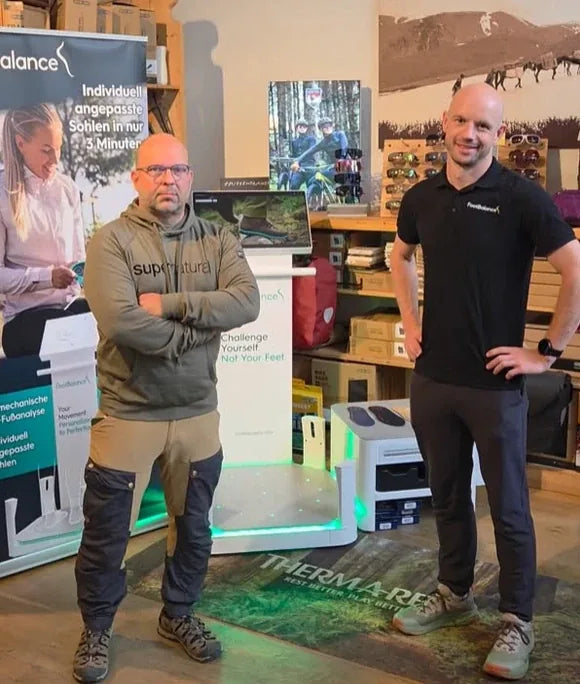 Tilo und ein Mitarbeiter von FootBalance neben dem Gerät zur Fußvermessung